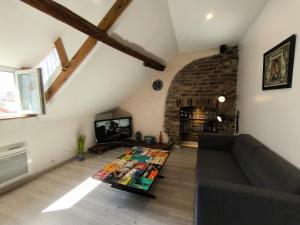 a living room with a couch and a tv at Ideal longue durée centre ville in Pau