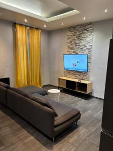 a living room with a large couch and a flat screen tv at T2 cosy proche commodités in Marseille