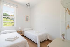 2 łóżka w białym pokoju z oknem w obiekcie Perbes Beach Terrace R w mieście Villanueva