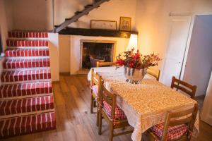 a dining room with a table and a staircase at La Corte sul lago in Ameno