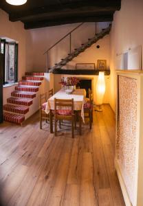 a dining room with a table and chairs and stairs at La Corte sul lago in Ameno +56 photos