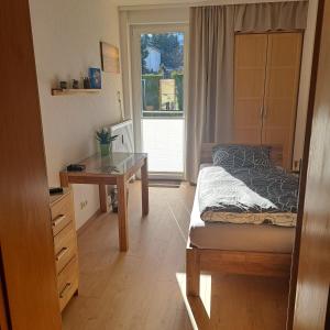 a bedroom with a bed and a desk and a window at Ferienwohnung Reichel in Freiberg +7 photos