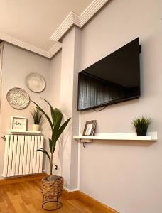 ein Wohnzimmer mit einem Flachbildfernseher an der Wand in der Unterkunft Dúplex León Centro in León