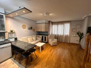 eine Küche und ein Wohnzimmer mit Tisch und Stühlen in der Unterkunft Dúplex León Centro in León