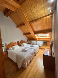 ein Schlafzimmer mit einem großen Bett und Holzdecke in der Unterkunft Dúplex León Centro in León