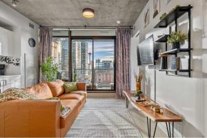 a living room with a couch and a large window at Miso 2 BD - Skyline View Patio Gym Pool & AC in Calgary