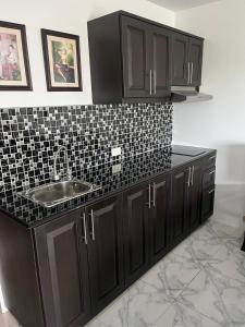 a kitchen with a sink and a black tiled counter at Sea sand Sun condominium 415 in Thang Kwian
