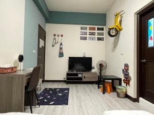 un soggiorno con TV e scrivania di 洄游民宿 Migration B&B a Donggang