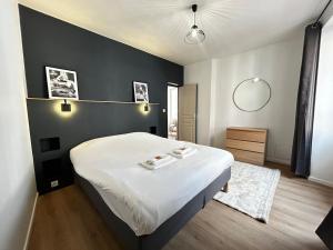 a bedroom with a bed and a black wall at E1 Reton magnifique T3 RDC terrasse et jacuzzi in Épernay