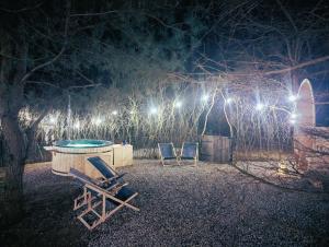 2 stoelen en 's nachts een zwembad met verlichting bij Forreset - leśny apartament, sauna i balia jacuzzi in Gietrzwałd