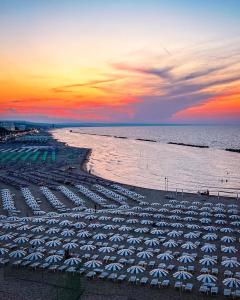 una spiaggia con ombrelloni e l'oceano al tramonto di Rio Mare a Termoli