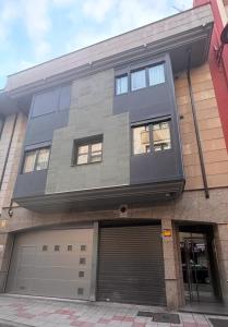 ein Gebäude mit Garagentor und ein Gebäude in der Unterkunft Dúplex León Centro in León