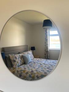 a bedroom with a bed with a round mirror at Almondbank Cottage - 2 Bedrooms, 8 miles from Portree in Skeabost