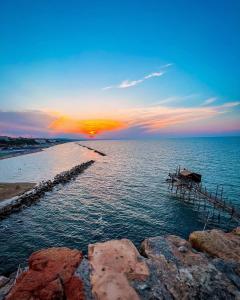 un molo in acqua con il tramonto sull'oceano di Rio Mare a Termoli
