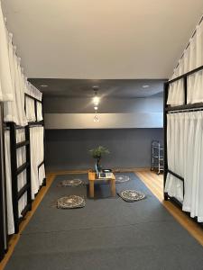 ハノイにあるHaNoi Homestay27の二段ベッド、テーブル、ラグが備わる客室です。