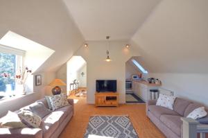 Black Barony Home Farm Cottage في إيدلستون: غرفة معيشة مع أريكتين وتلفزيون