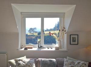 Black Barony Home Farm Cottage في إيدلستون: نافذة مع حوض في غرفة المعيشة