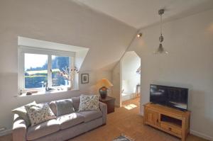 Black Barony Home Farm Cottage في إيدلستون: غرفة معيشة مع أريكة وتلفزيون بشاشة مسطحة +10 صور