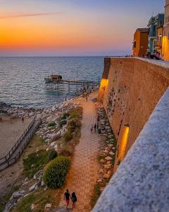Un gruppo di persone che camminano lungo un marciapiede vicino all'oceano di Rio Mare a Termoli Altre 2 foto