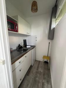 a small kitchen with a sink and a microwave at Studio et terrasse près de Paris in Suresnes