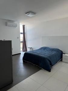 a bedroom with a blue bed in a white room at FH rooms in Crotone