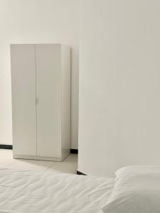 a bedroom with a white bed and a cabinet at FH rooms in Crotone