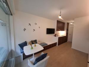 Una sala de estar con una mesa y una cocina. en Studio-R, en Middelkerke