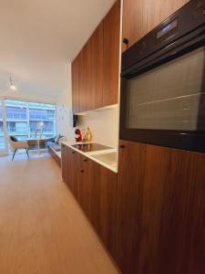 Una cocina con microondas y una sala de estar. en Studio-R, en Middelkerke