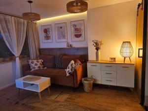 ein Wohnzimmer mit Sofa und Tisch in der Unterkunft Apartament Pienińska Sowa in Szczawnica