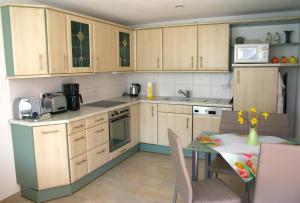 a kitchen with wooden cabinets and a table with a dining room at Erzgebirgsferien in Olbernhau