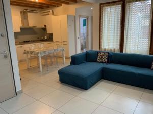 a living room with a blue couch and a table at Palazzo Penzo Bellemo in Chioggia