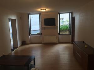 an empty living room with a tv and a couch at CHAPELLE ST NICOLAS in Roanne