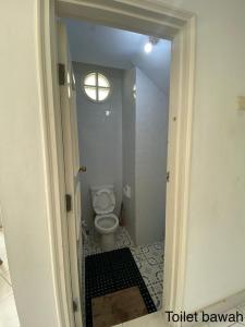 a bathroom with a toilet and a window at Via puncak resort in Cikundul +13 photos