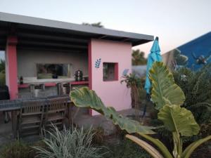a small pink house with a table and a kitchen at la villa TIKALIKATA in Saint-Joseph