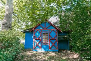 a small blue house in the middle of trees at Château de Waleffe in Les Waleffes