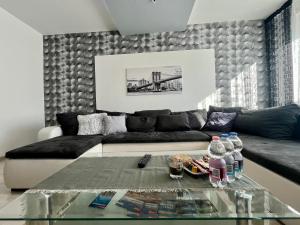 a living room with a couch and a glass table at GreatForestSportAndSpaUniversityFlat in Debrecen