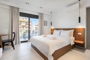 a bedroom with a large bed and a balcony at Athens Genesis Luxury Suites By SEM in Athens