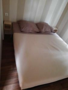 a white bed with two pillows on it in a room at Mobil home - N025 in Boofzheim