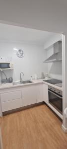a white kitchen with a sink and a stove at Apartamento Azul in Nerja