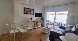 a living room with a couch and a table and chairs at Apartamento Azul in Nerja