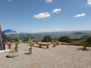 a patio with a table and potted plants and mountains at Cabana das montanhas in Bueno Brandão