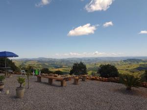 a table and benches on a hill with a view at Cabana das montanhas in Bueno Brandão