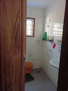 a bathroom with a toilet and a sink at Charmante maison près de Cotonou in Cotonou +13 photos
