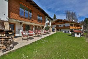 eine Terrasse mit Stühlen und einem Tisch vor einem Haus in der Unterkunft Tourist Hotel Boehm in Schönau am Königssee