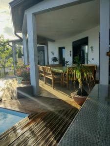 a patio with a table and chairs and a house at la villa TIKALIKATA in Saint-Joseph