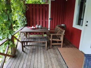 a wooden table and chairs sitting on a deck at Sköna stugan in Kolmården
