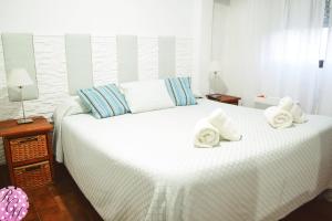 a bedroom with a white bed with towels on it at Rocio Club de Mar in Mar del Tuyú