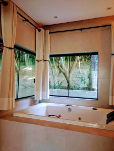 a large bath tub in a room with a window at Cabanas Privativas com Jacuzzi, Cozinha, Churrasqueira e Decoração - Sitio Pauletto in Jarinu