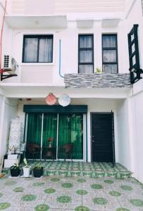 a white house with black doors and a patio at De Richness in Tagbilaran City