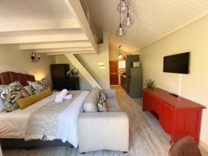 a living room with a large bed and a television at The Willow Suite - Larola 35 in Clarens